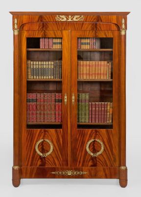 an antique wooden bookcase with many books on top of it