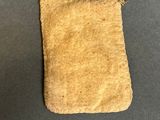 an old bag with a string attached to it sitting on a table