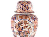 un vase orange et bleu posé sur une table blanche