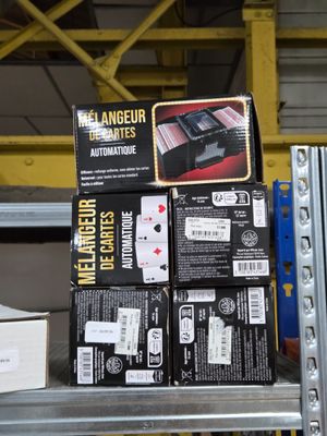Des cartons contenant du matériel électronique sont empilés sur une étagère dans un entrepôt