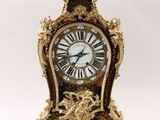 a gold clock with roman numerals on it
