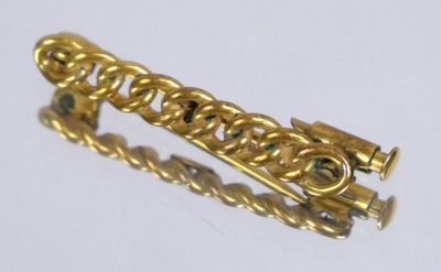 a close up of a gold bracelet on a white surface