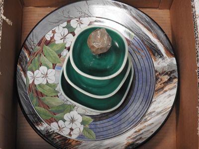 a box that has a plate in it with a rock on it