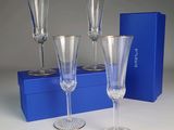 trois verres à vin vides posés à côté d'une boîte bleue sur une table