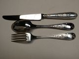 trois fourchettes et un couteau posés sur une table