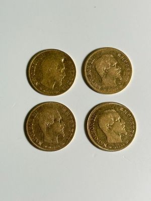four gold coins sitting on top of each other on a white surface