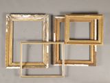 three gold picture frames on a gray wall with a white background