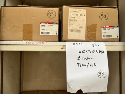 une pancarte posée sur une étagère dans une pièce où se trouvent des cartons