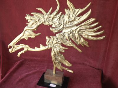 statue of a golden horse on a wooden base on a red cloth
