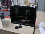 un téléviseur posé sur une table, avec une télécommande dessus