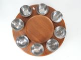 a wooden plate with several metal bowls on it