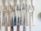 a lot of forks and spoons that are on the table