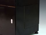an image of a small black cabinet with a door and a drawer