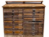 une vieille armoire en bois comportant de nombreux tiroirs et surmontée d'autres tiroirs