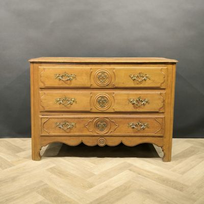 a wooden chest of drawers on a chevroned wooden floor