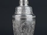 a silver plated cocktail shaker on a black background