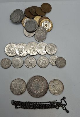 some silver coins and a chain are on a white surface