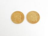 deux pièces d'or posées sur une surface blanche, sur fond blanc
