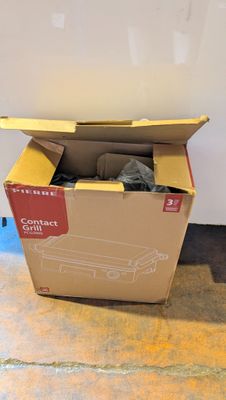 une boîte en carton contenant une paire de chaussures, posée par terre