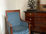 une chaise bleue dans un coin d'une pièce dont le sol est à carreaux noirs et blancs
