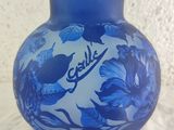 a blue vase with blue flowers on it sitting on a table