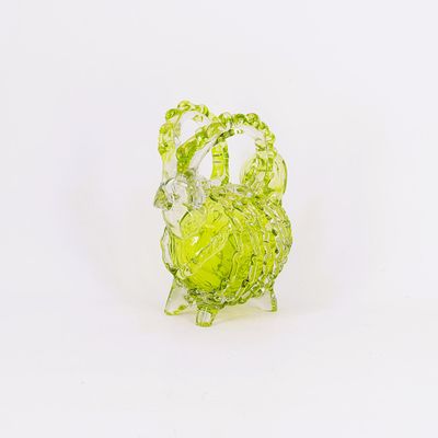 une figurine en verre représentant un chou, posée sur une surface blanche