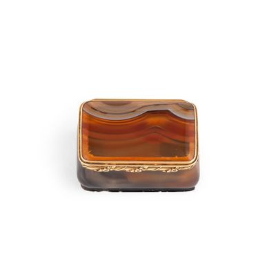 a close up of a brown and black box on a white surface