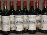 six bouteilles de vin sont alignées sur une table