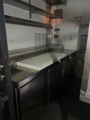 une cuisine avec des placards en inox et un plan de travail blanc