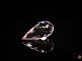 a close up of a pink diamond on a black surface