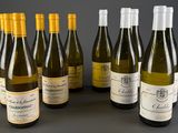 six bouteilles de vin sont alignées sur une table
