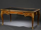 un bureau avec un plateau noir et des ornements dorés