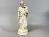 a statue of a man holding a baby in his arms