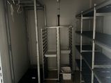 a small room with shelves and bins in it