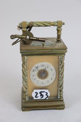 a small clock with a key on top of it