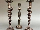 two metal candles are sitting on top of each other on a table