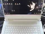 un ordinateur portable blanc posé sur une table noire