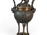 un ancien brûle-parfum en bronze surmonté d'un oiseau