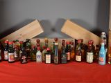 many bottles of alcohol sitting on a table with a red cloth