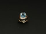 une image d'une bague avec une topaze bleue entourée de diamants