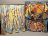 deux tableaux exposés dans un coin d'une pièce aux murs blancs