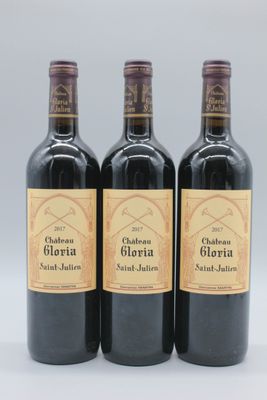 trois bouteilles de vin rouge posées sur une table blanche
