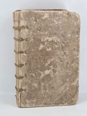 an old book is sitting on a table with a white background