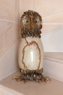 an owl figurine sitting on top of a set of stairs