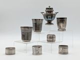plusieurs vases et tasses en argent posés sur une étagère transparente