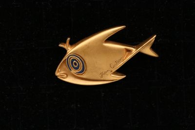 une broche en forme de poisson rouge ornée d'un motif en spirale