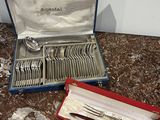 a box of silverware sitting on a table next to a knife and fork