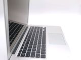 a silver laptop with a black keyboard on a white surface