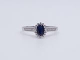an oval sapphire and diamond ring on a white background