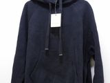 a black hoodie hanging on a hanger on a white wall